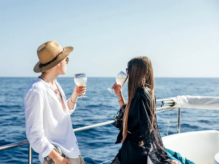 Two guests drink a glass of champagne on board the victus vision yacht.